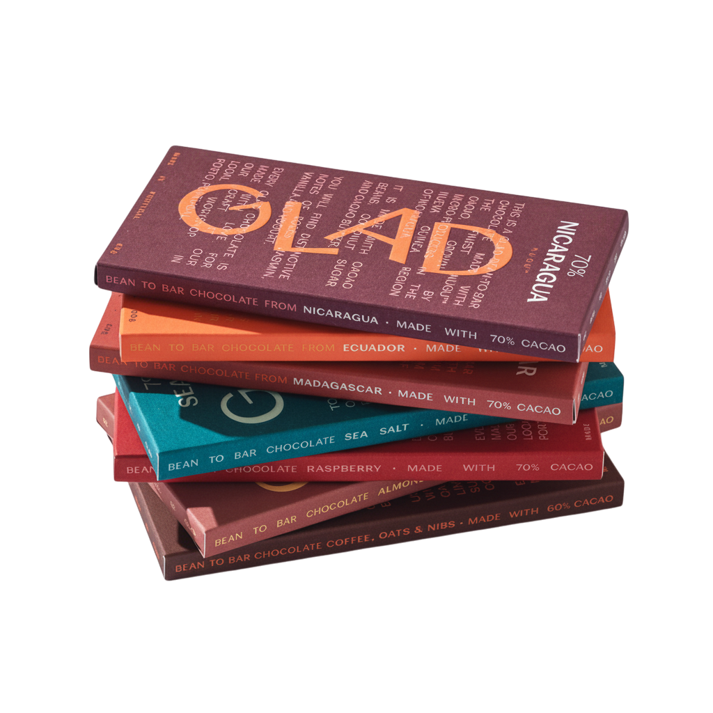 Colheita stack of GLAD bean-to-bar dark chocolate bars in various colourful paper wrappers on a white background